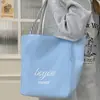 2025 Nuevo Modelo Cruzada Roja Gran Capacidad Lona Rayada Estilo Coreano Estilo Perezoso Portátil Hombro Tote Bolsa de Compras