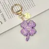 Nova Chaveiro Trevo de Quatro Folhas Cheio de Diamantes de Argila de Cristal Exquisito Pingente de Carro com Pedras Strass Embutidas Bolsa de Luxo Leve