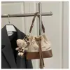 Bolsas Femininas 2025 Nova Coleção Outono e Inverno Bolsas Femininas com Estampa de Letras Estilo Nicho Bolsa de Ombro em Camurça Bolsa Transversal Estilo Balde