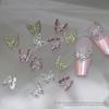 Brocas para uñas con forma de mariposa hueca de aleación con explosiones transfronterizas, venta al por mayor, con diamantes tridimensionales, adornos para uñas de metal dorado y plateado.