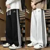 Pantalones casuales rectos para hombre, pantalones de pierna ancha holgados de moda para otoño con tres rayas, versátiles para adolescentes, adecuados para deportes