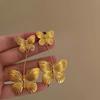 Pendientes de borlas de mariposa con perla antigua de aguja plateada, pendientes distintivos creativos de nicho, pendientes de estilo metálico de lujo ligero y avanzado.