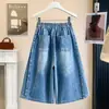 Foto real de shorts de mezclilla vintage azules talla extra para mujer, verano 2026, shorts holgados de pierna ancha de longitud media de cintura alta con retazos