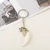 Fabricantes de chaveiros de liga metálica mais vendidos no exterior vendendo chaveiro de pena de marfim pingente decorativo para carro