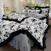 Conjunto de quatro peças em veludo de leite estilo francês, apresentando uma capa de edredom de fleece coral, espessa e quente, com acabamento em renda, e um cobre-leito acolchoado que é lavável à máquina