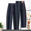 Jeans feminino azul escuro de cintura alta, corte reto (estilo cenoura), modelagem solta, com barra dobrada, comprimento cropped e efeito emagrecedor, modelo 2026