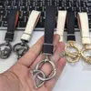 Exquisito Colgante Llavero de Cuero para Coche Accesorio de Bolso, Parche de Cuero Personalizado y de Moda Blanco y Negro Llavero de Nicho al por Mayor
