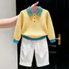 Roupas infantis coreanas coleção outono/inverno 2026: suéter de tricô amarelo texturizado com gola alta e calça branca casual de perna reta