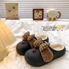 Chinelos de algodão impermeáveis com laço de bolinhas fofos para mulheres, apresentando cabedal de couro, forro de fleece e design espessado para aquecimento e resistência ao escorregamento, perfeitos para uso interno no outono e inverno.