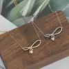 Chapado en oro real microincrustado con circonita cadena para clavícula de temperamento diseño de nicho femenino sentido de diseño collar con colgante de lazo gota de agua venta al por mayor