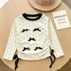 Nueva colección de primavera y otoño: Camisetas básicas lindas de manga larga y cuello redondo para niñas, con adorables estampados de moños, disponibles al por mayor