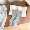 Calcetines coreanos bordados con dibujos de cachorros para mujer, de primavera y verano, estilo universitario, de color contrastante, de tamaño mediano, en blanco y negro, con diseño apilado en gris.