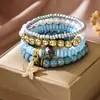 Novo bracelete de verão europeu e americano estilo férias de praia com estrela-do-mar, concha, pérola, bracelete de cordão trançado elástico para mulheres, atacado