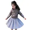 Ropa infantil estilo coreano 2026 colección otoño e invierno nueva: cárdigan de punto gris dulce con lazo para niña y falda de cuadros azules, moderno