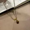Nova Corrente de Suéter com Pingente de Cabacinha Olho de Tigre Tecida Preto e Dourado Tendência Outono/Inverno com Novo Estilo Chinês e Sensação Exquisita de Alto Padrão