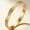 Pulsera de acero de titanio chapada en oro con trébol de cuatro hojas incrustado de diamantes, brazalete abierto de cierre de lujo ligero que no se decolora, stock de fábrica al por mayor