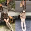 Sin embargo, estas son botas vaqueras de tacón alto de gamuza estilo retro para mujer, que llegan hasta la rodilla, con punta fina, tacón delgado y detalle de hebilla metálica.