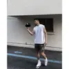 Camiseta esportiva fitness de verão sem mangas ombro a ombro estilo americano transfronteiriça, gola redonda solta, cor sólida, manga curta, colete trendy ins masculino