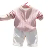 Ropa infantil coreana 2026 colección otoño/invierno nueva: conjunto de suéter rosa de punto trenzado, cárdigan de punto y pantalones casuales blancos para niños y niñas