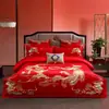 Juego de cuatro piezas de algodón de fibra larga de Xinjiang de alta gama para boda en color rojo brillante con bordado de dragón y fénix, juego de ropa de cama de múltiples piezas de algodón puro