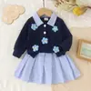 Atacado transfronteiriço de roupas para meninas: camisas com estampas florais, saias curtas listradas e blusas estilo preppy