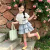 Conjunto de Verão Manga Curta para Meninas 2026 Novo Estilo Coreano Infantil Casual de Verão Bolo Saia Curta Conjunto Elegante de Duas Peças