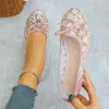 Sapatilhas de tela sem cadarço, com bico baixo e detalhe de laço para mulheres, bordadas com pequenas flores, criando um visual charmoso de sapatilha de balé, disponíveis na Europa e nos EUA.