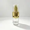 Venta al por mayor de botellas de vidrio de alta transparencia con rayas verticales y cabezales de bomba dorados brillantes, adecuadas para sérums, cremas de diamante y productos para el cuidado de la piel.; materiales de embalaje de vidrio