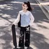 Un atuendo fresco y vibrante inspirado en la dopamina: una camisa con cuello de muñeca combinada con pantalones de pierna ancha, creando un look dulce y adorable para niñas
