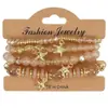 Pulseras multicapa al por mayor, juego de cuatro piezas de joyería con cuentas de artesanía en vidrio, juego de pulseras elásticas, accesorio de mano con soporte de flor de hierro