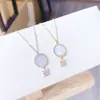 Chapado al vacío conservador de color oro real moda europea y americana ángel colgante redondo carcasa de acero de titanio collar joyería para mujer al por mayor
