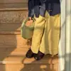La nueva colección de otoño 2026 para niñas estilo bosque incluye una sencilla camisa de cuadros con cuello, un chaleco de punto con botones de cuerno y pantalones de pierna recta.