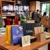 Sacolas de presente de papel kraft, disponíveis em estoque, podem ser personalizadas com logotipos, oferecendo um visual de alta qualidade; adequadas para embalar óculos, cigarros e bebidas alcoólicas; atacado disponível