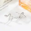 Pendientes de clip para orejas con forma de serpiente para niñas sin perforaciones, pendientes de diseño de nicho para otoño e invierno, accesorios para orejas de diseño minimalista estilo europeo y americano de comercio exterior