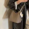 Bolsa transversal simples e estilosa com design vintage, apresentando um padrão delicado, adequada para o outono de 2026, e um novo estilo de ombro