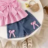 Conjunto de verano estilo europeo y americano transfronterizo: Camisola de rayas rosas con detalle de lazo y shorts de mezclilla, al por mayor para niños