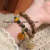 Pulsera de madera de agar, accesorio cultural de madera, hebilla de paz de ámbar y hueso de camello de segunda generación, borla de doble bucle, con bloques de color, elegante y vintage para mujer