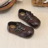 Sapatos infantis de couro, novo estilo 2026, com sola macia e antiderrapante, adequados para primavera e outono, design moderno para meninos e meninas, com fecho de fivela dupla