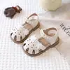Sandálias Infantis Femininas Estilo Novo Verão 2026 Sapatos de Princesa Sapatos de Bebê Biqueira Fechada Flor Vazada Pérola Velcro Sandálias de Solado Macio