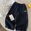 Calça Longa Infantil 2026 Outono Nova Chegada Estilo Coreano Casual Bolso Bloco de Cores Calça de Moletom para Meninos e Meninas, Calça de Bebê Macia e Moderna