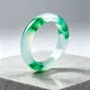 Pulsera de jade de alta calidad con una textura clara y helada y vibrantes patrones florales verdes. El jade es excepcionalmente claro y el diseño floral es vívido, realzando la elegancia de quien lo lleva.. Venta al por mayor de exquisitos brazaletes de jade para mujer