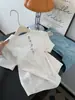 Camiseta Blanca Asimétrica Hueca de Cuello Redondo Manga Corta para Mujer, Corte Holgado, Diseño Adelgazante, Estilo Corto, Top de Hombro Regular, Primavera 2026