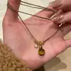 "Latido Ámbar" Colgante Círculo Piedra Ojo de Tigre Melard, Cadena Clavícula Negra Dorada de Alta Gama Estilo Chanel para Mujer