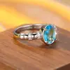 Anillo de estilo europeo con piedra principal ovalada de aguamarina, aro de luz, sensación de lujo de alta gama, diseño denso de pavé con pequeños diamantes en ambos lados