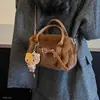 Bolso de mano para mujer estilo commuter, minimalista y sutilmente lujoso para el otoño de 2026, con un diseño afelpado, versátil para llevar al hombro o cruzado.