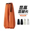 Pantalones de pierna ancha, de corte curvo y deconstruidos para hombre, de estilo high-street 2026, con hebilla y cintura elástica, una silueta fluida, diseño de pierna ancha y corte hasta el suelo, creando un look elegante y deportivo