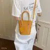 Nuevo bolso bandolera de un solo hombro 2026, moderno estilo coreano, bolso de cubo versátil de moda de nicho para mujer, diseño tejido