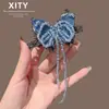 Pinza para el pelo de cristal azul con mariposa de nuevo estilo coreano y japonés, de lujo ligero, para mujer, pinza de resorte para flequillo lateral con borla, accesorio para el pelo versátil y elegante