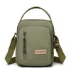 Bolso de hombro y cruzado para mujer de lona de nailon nuevo, bolso pequeño moderno y versátil, bolso para teléfono portátil multicapa, bolso de mano simple