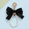 Llavero estilo Ins de satén con lazo y perla, colgante de corazón con diamante, correa para teléfono, accesorio de decoración para bolso